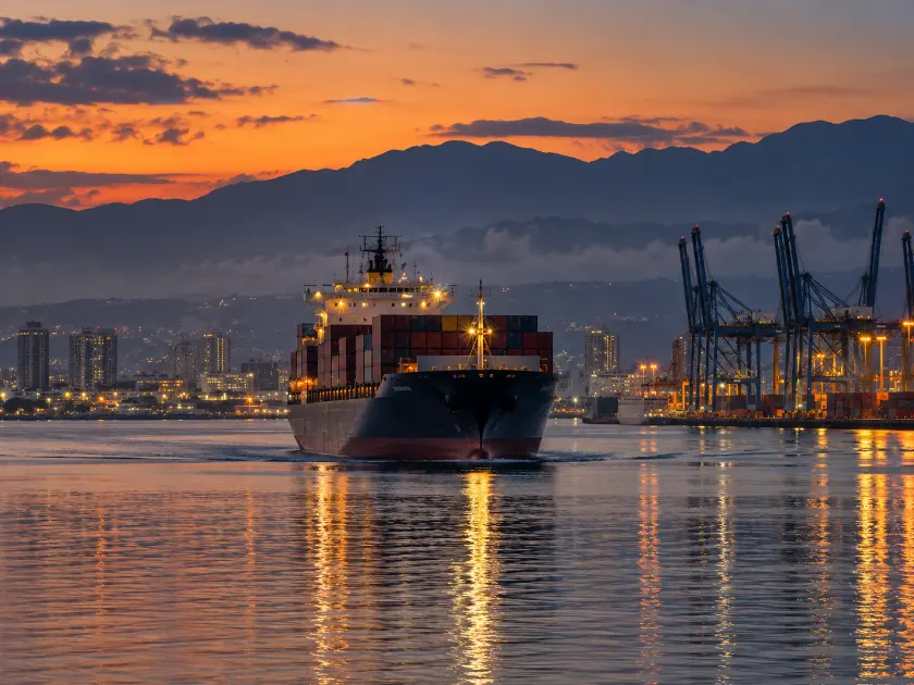 Cargo ship arriving in Kingston Harbour at dusk